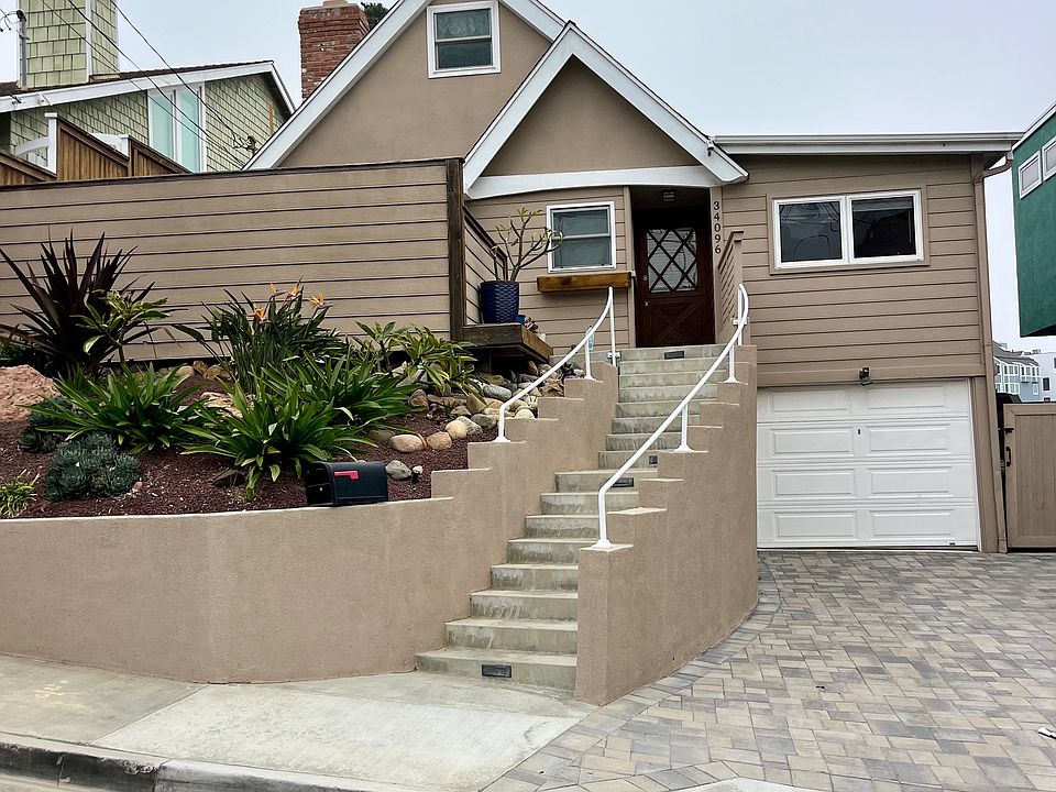 New pavers on the driveway and enclosed garage! Beautifully landscaped, comes with a gardener. Private front patio and enclosed surf board storage. Solar is esthetically hidden from view on the roof. Solar saves money on utilities! Rare new A/C!