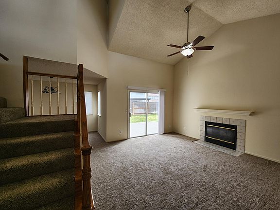 Enjoy this living room for the holidays with spacious vaulted ceilings, cozy fireplace, new carpet.