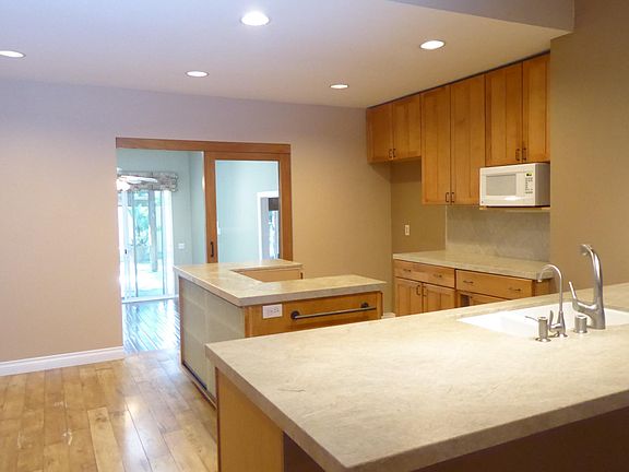 Kitchen with granite counter tops and island. Plenty of cabinet space and full walk-in pantry (down 3 steps behind the glass sliding door).