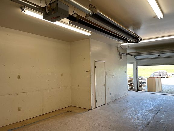 The garage door and standard entrance, see open space in back for parking