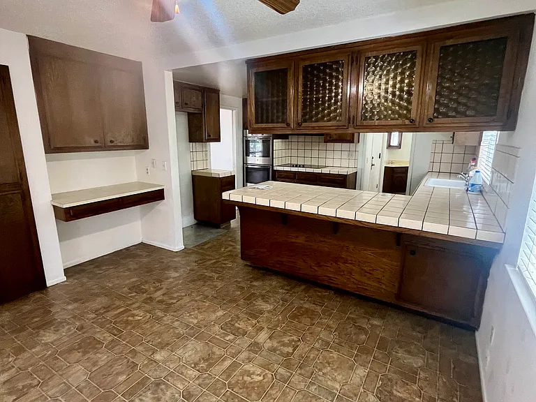 Peninsula breakfast bar and dinette space. In the background, there is a laundry room and a half bathroom.