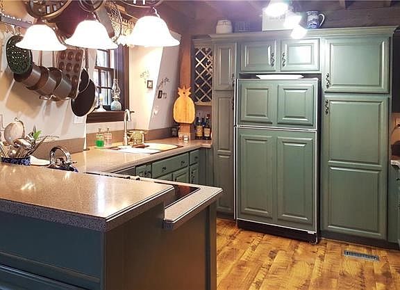 Kitchen has custom cabinetry with loads of pullouts, crown molding, wine rack and solid surface counters.