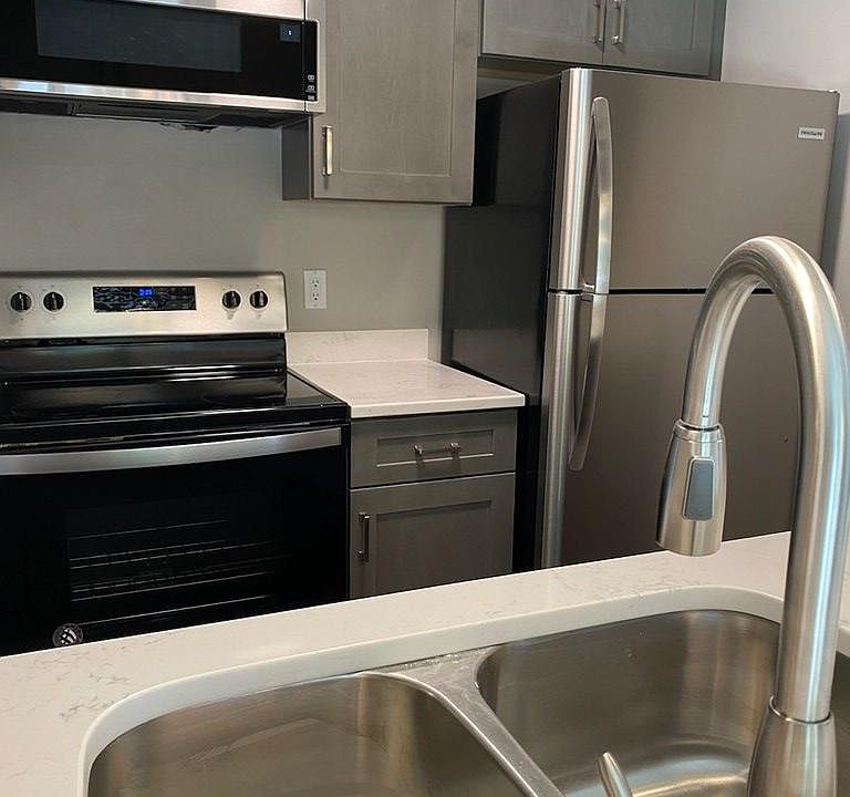 Fully renovated kitchen with new cabinets and appliances and a quartz countertop. Low profile microwave built in and a disposal in the under mount stainless steel sink.