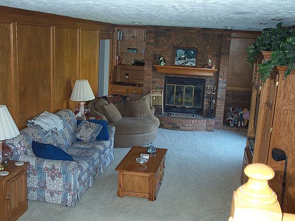 Cozy family room with rich wood paneling. Fireplace side shelves & Wet bar
