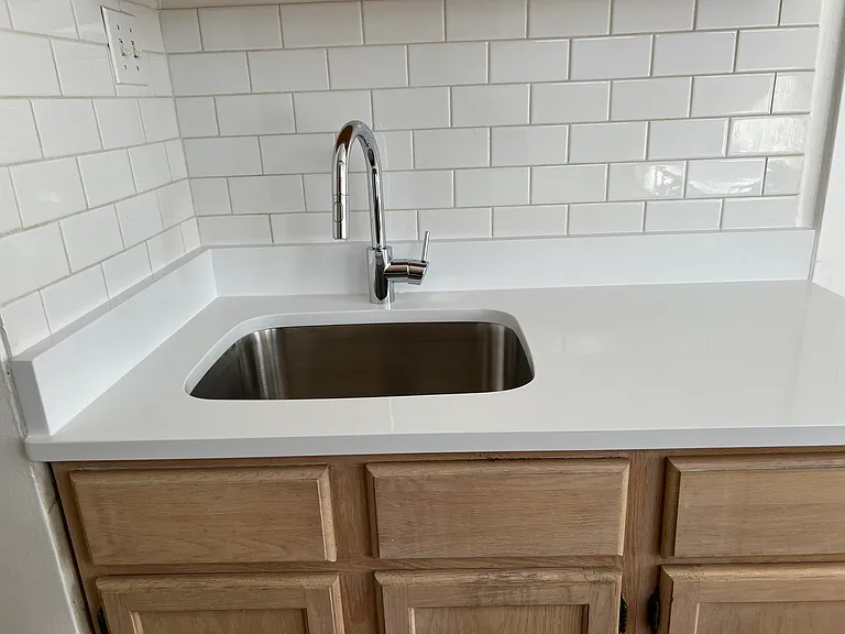 NEW white Quartz countertop.
NEW Grohe gooseneck faucet.
NEW 10" deep SS sink.
Subway tile backsplash.