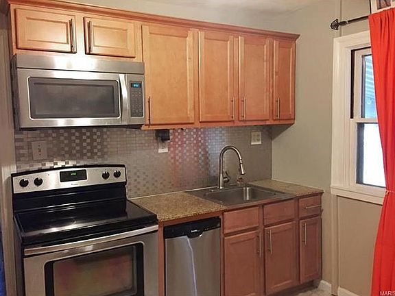 Updated kitchen with stainless steel appliances and metal backsplash