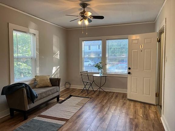 Enter into the spacious living space with high ceilings, wood laminate flooring, large windows letting in ample natural light, ceiling fan, two-tone paint to highlight the original period picture moldings.