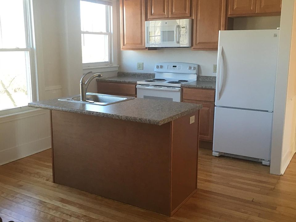 Kitchen facing east - microwave, stove, fridge. Island for bar stool seating, Dishwasher located on kitchen island