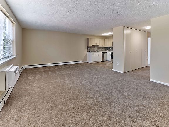 Spacious living area with natural light at Audubon Arms Apartments