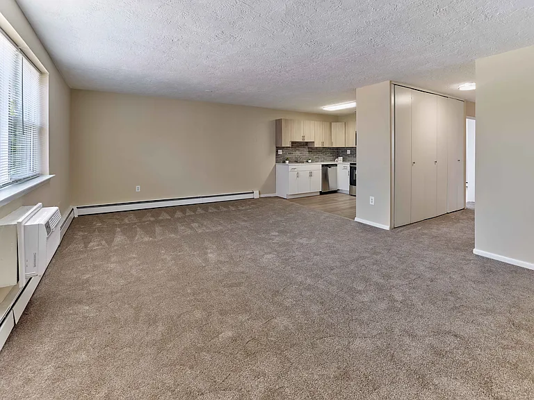 Spacious living area with natural light at Audubon Arms Apartments