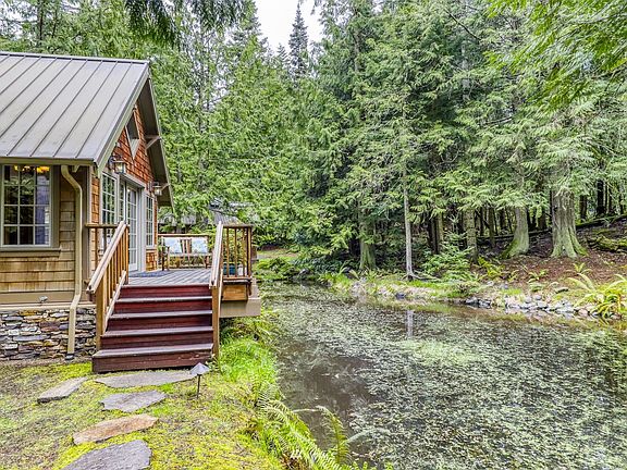 A picturesque stone path leads to the front deck and entry which overlooks a large pond.  