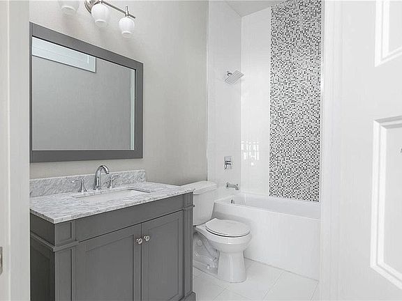 Updated bathroom with full vanity, tub and rain shower head
