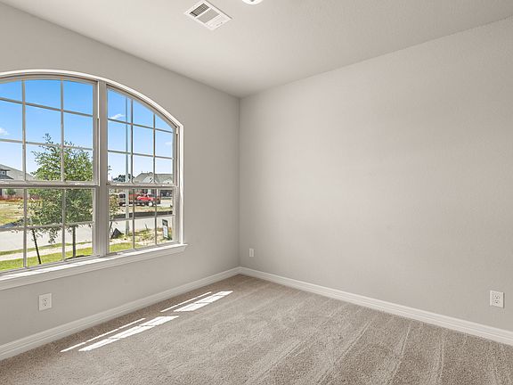 The secondary bedroom features plush carpet, fresh paint and a large window that lets in plenty of n