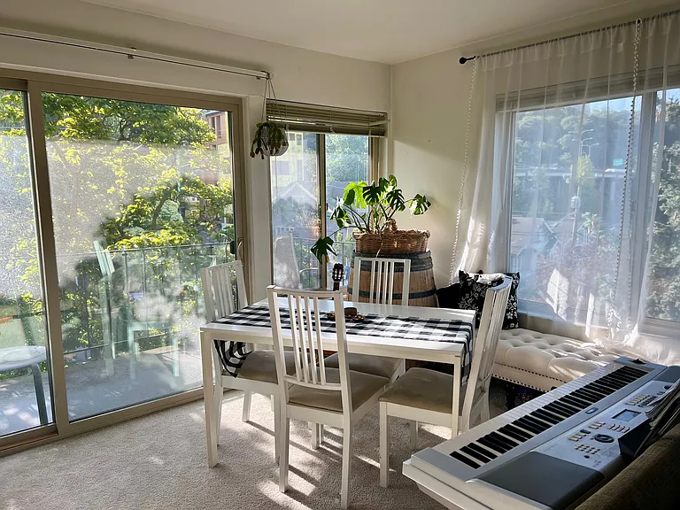 Living room and dining area with south and west view of Downtown Seattle, Space Needle, Lake Union, and east facing for balcony for morning sun into living area