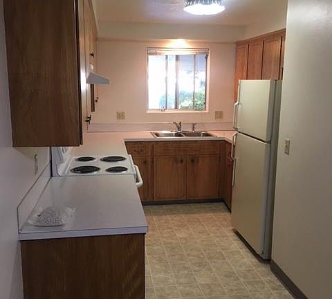 Kitchen has Window, Self cleaning GE Oven, Refrigerator & Wood Cabinets