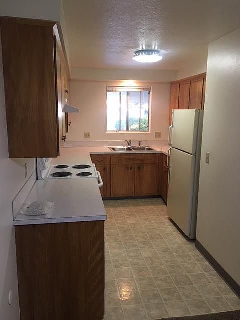 Kitchen has Window, Self cleaning GE Oven, Refrigerator & Wood Cabinets