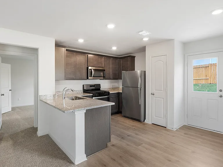 The kitchen has gorgeous wood cabinetry.