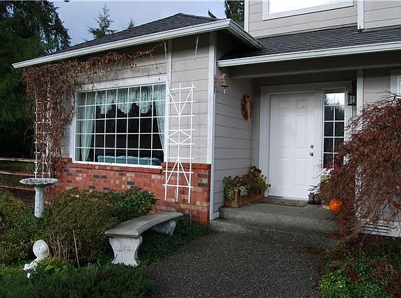 Lots of cute bird houses that are mixed with the palate of colorful flowers 