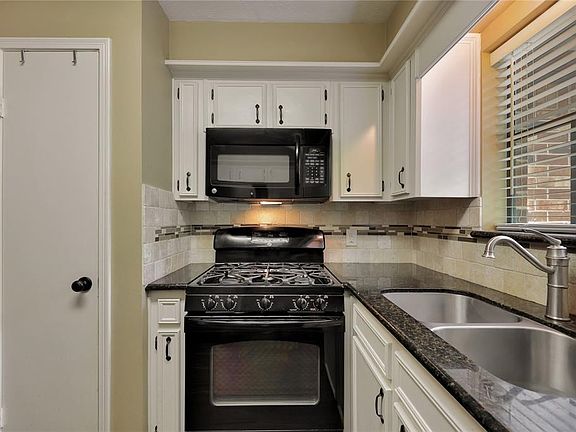 Another view of the updated kitchen sink faucet and designer inlay stone back splash !