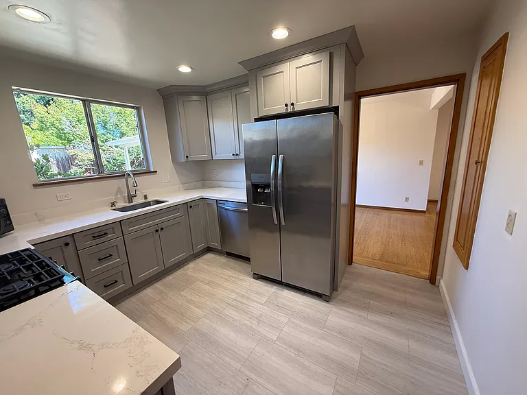 Efficient kitchen is equipped with stainless steel appliances and soft-close cabinetry and quartz countertop.
