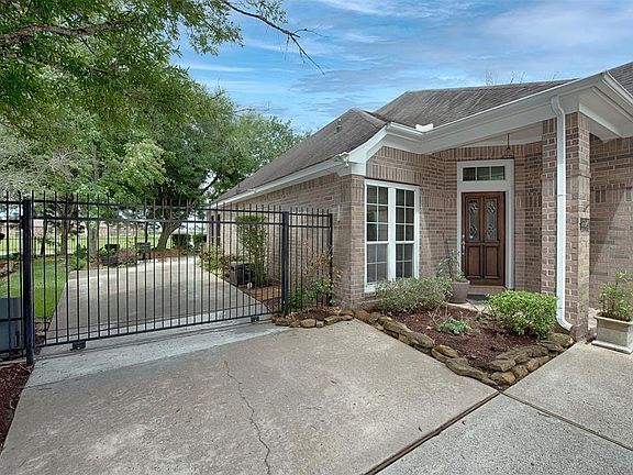Along the side of the home is a security gate to the backyard with even more driveway parking.