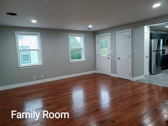Living room with tons of natural day light as well as recessed lighting.