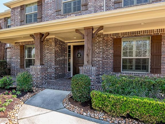 A charming front porch surrounded by a lush landscape is sure to greet your guests in style!