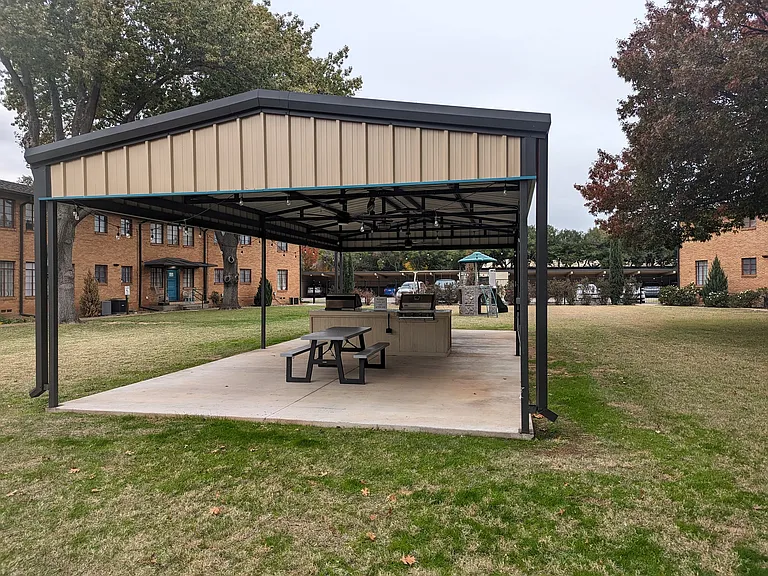 Spacious covered outdoor amenity with picnic table seating and grill station, adding everyday convenience and a great shared space for residents.