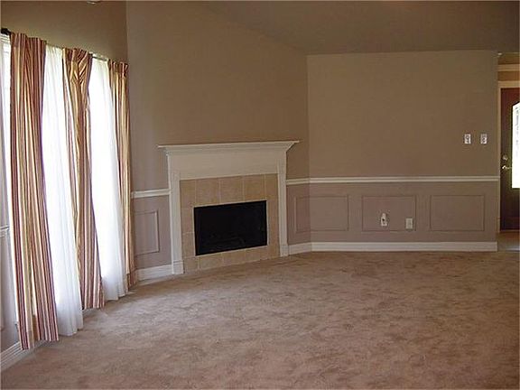 Corner fireplace, high ceilings, recent interior paint and carpet await a new owner!