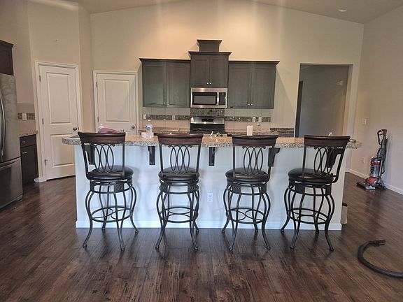 Sitting kitchen bar features 4 chairs. Food pantry and door to garage.