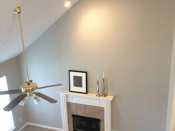 Living room features two-floor vaulted ceiling and fireplace