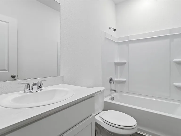 Bathroom vanity featuring an integrated sink, polished chrome faucet, and expansive mirror