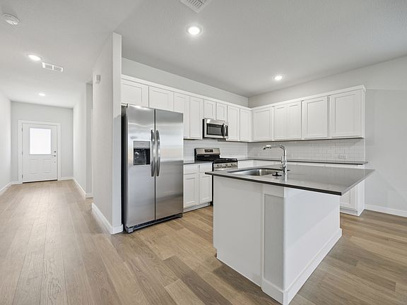 Kitchen in the Haylee home plan by Trophy Signature Homes - REPRESENTATIVE PHOTO