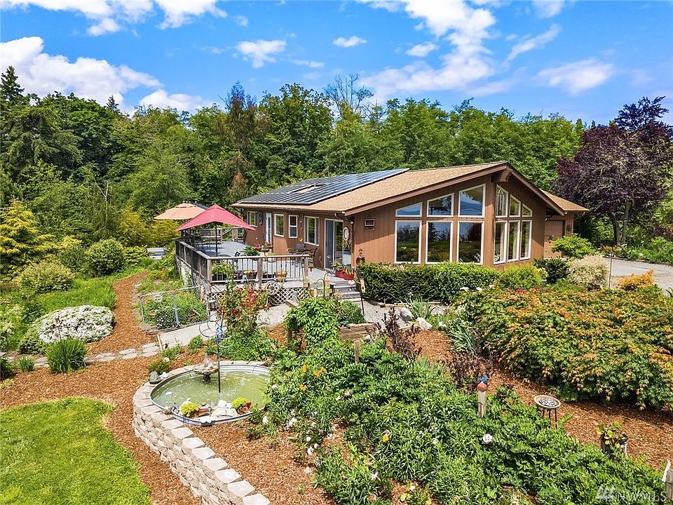 This welcoming home is nestled into lovingly created gardens and surrounded by fields and forest. The birds love it here! 10KW solar feeds back into the grid.