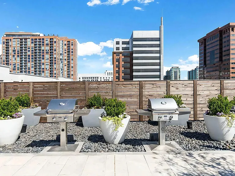 Outdoor Grill Area on Rooftop Deck With Privacy Fence and Seating
