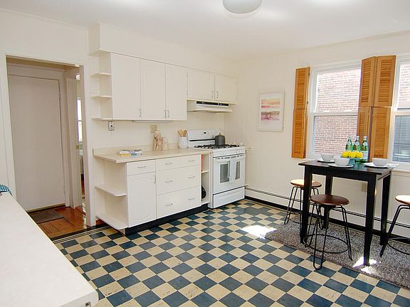 Kitchen now has new white tile flooring.