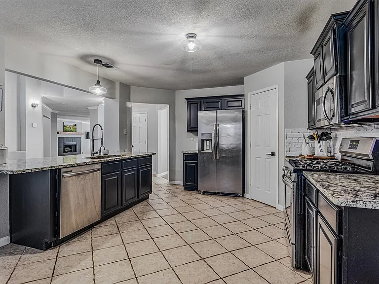 Kitchen with dark cabinetry and granite countertops