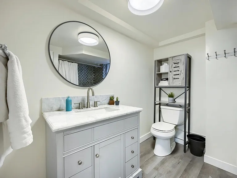 Full bathroom featuring full-size tub, shower and new marble-top vanity and new fixtures. There is also additional storage space.