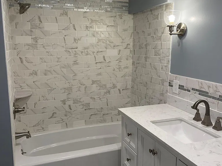 Newly renovated bathroom with beautiful classic marble tile. Lots of storage and tub/shower