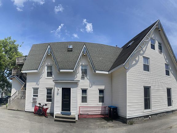 Parking lot view with a convenient wrap-around driveway. Your apartment is situated at the back, offering peaceful, uninterrupted garden views_perfect for a tranquil and private living experience.