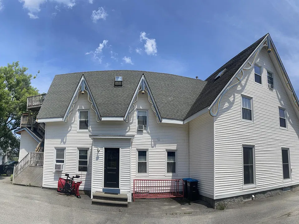 Parking lot view with a convenient wrap-around driveway. Your apartment is situated at the back, offering peaceful, uninterrupted garden views_perfect for a tranquil and private living experience.