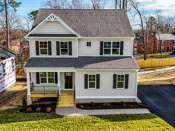 This charming two-story white house on Lot 31 in Poplar Village features a front porch, driveway, an