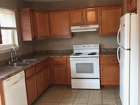 Kitchen with nice white appliance, Cabinets have crown molding with nice handles and the floor tile is relatively new.