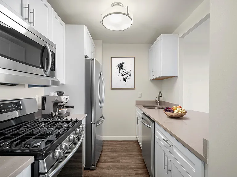 Modern kitchen with six-burner gas stove, sleek stainless steel appliances, elegant cabinetry, stone countertops and large refrigerator at Parkside Place, apartments in Cambridge, MA