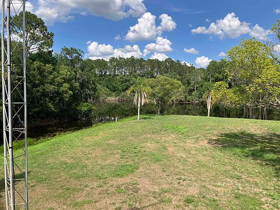 Outside view 1 of 2 showing empty lot and waterway in background