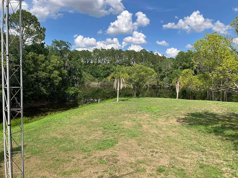 Outside view 1 of 2 showing empty lot and waterway in background