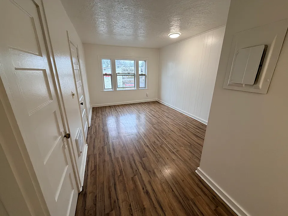 Spacious living room with fresh paint, lots of light, and laminate flooring.