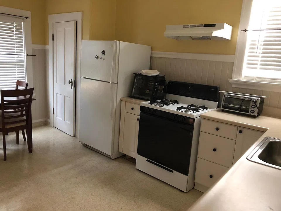 Kitchen with pantry, refrigerator, and gas stove.