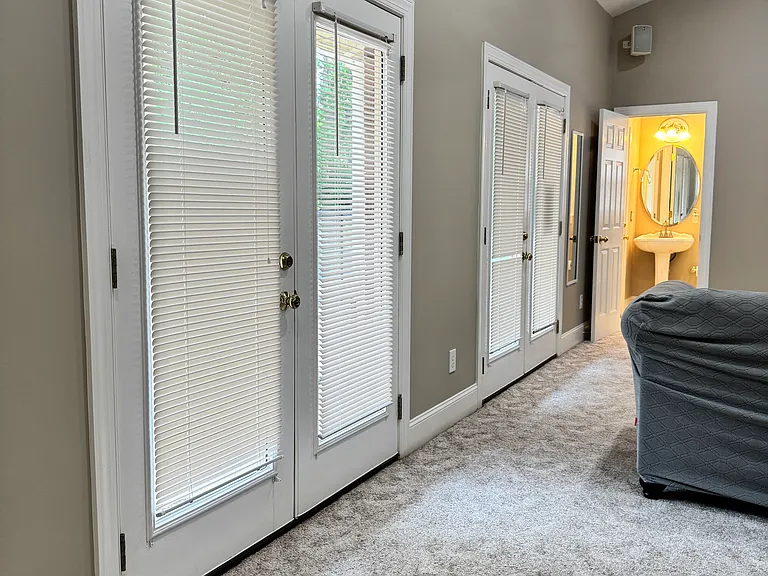 Bright, sunlit space with French doors that open directly to the backyard pool and lounge area.