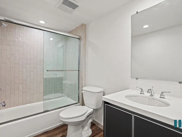 Bathroom with Bathtub with Glass Door and Vanity Cabinet Storage